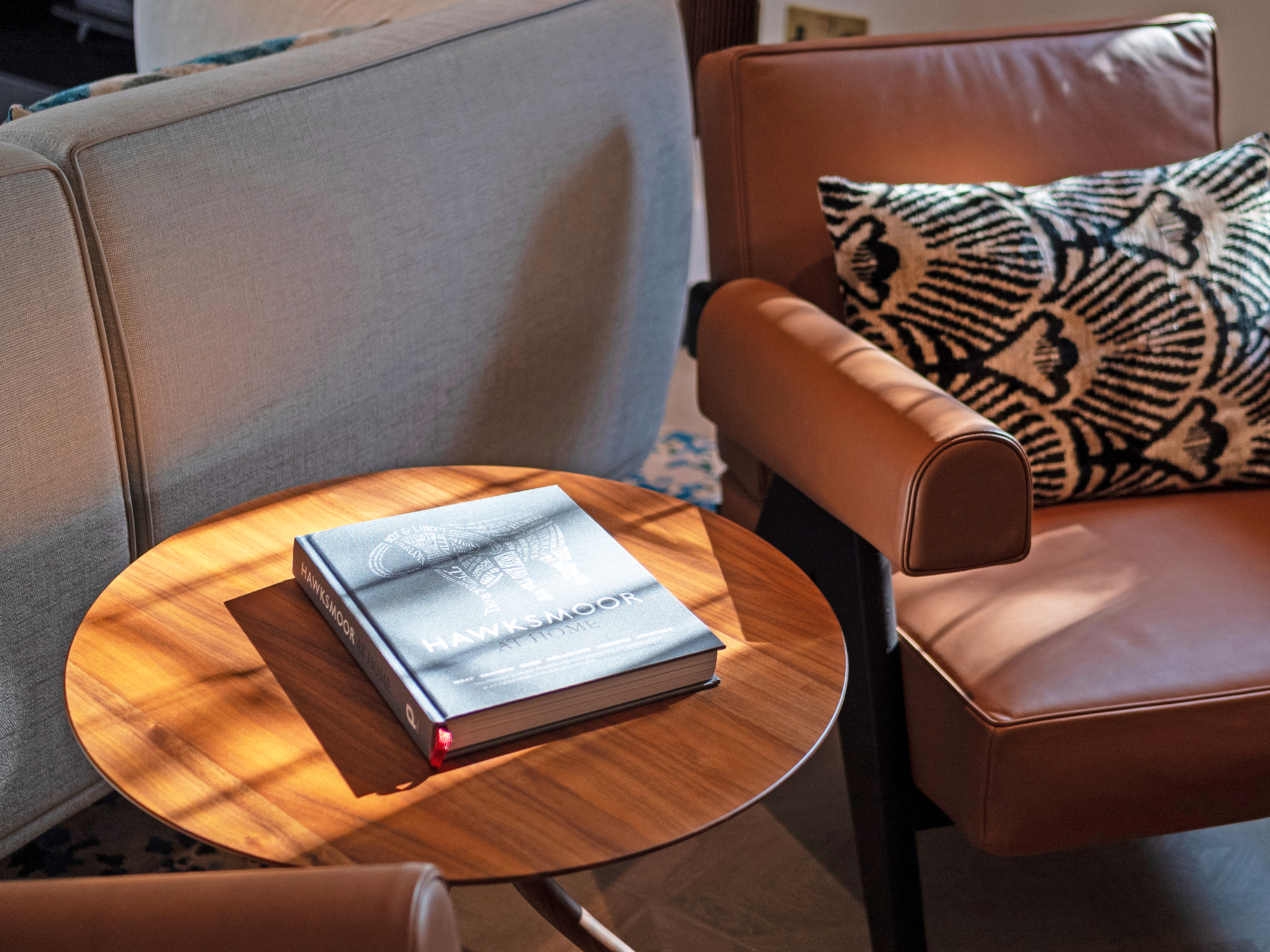 A beautifully staged luxury home interior in Berkshire featuring a coffee table book and elegant leather armchair styling.